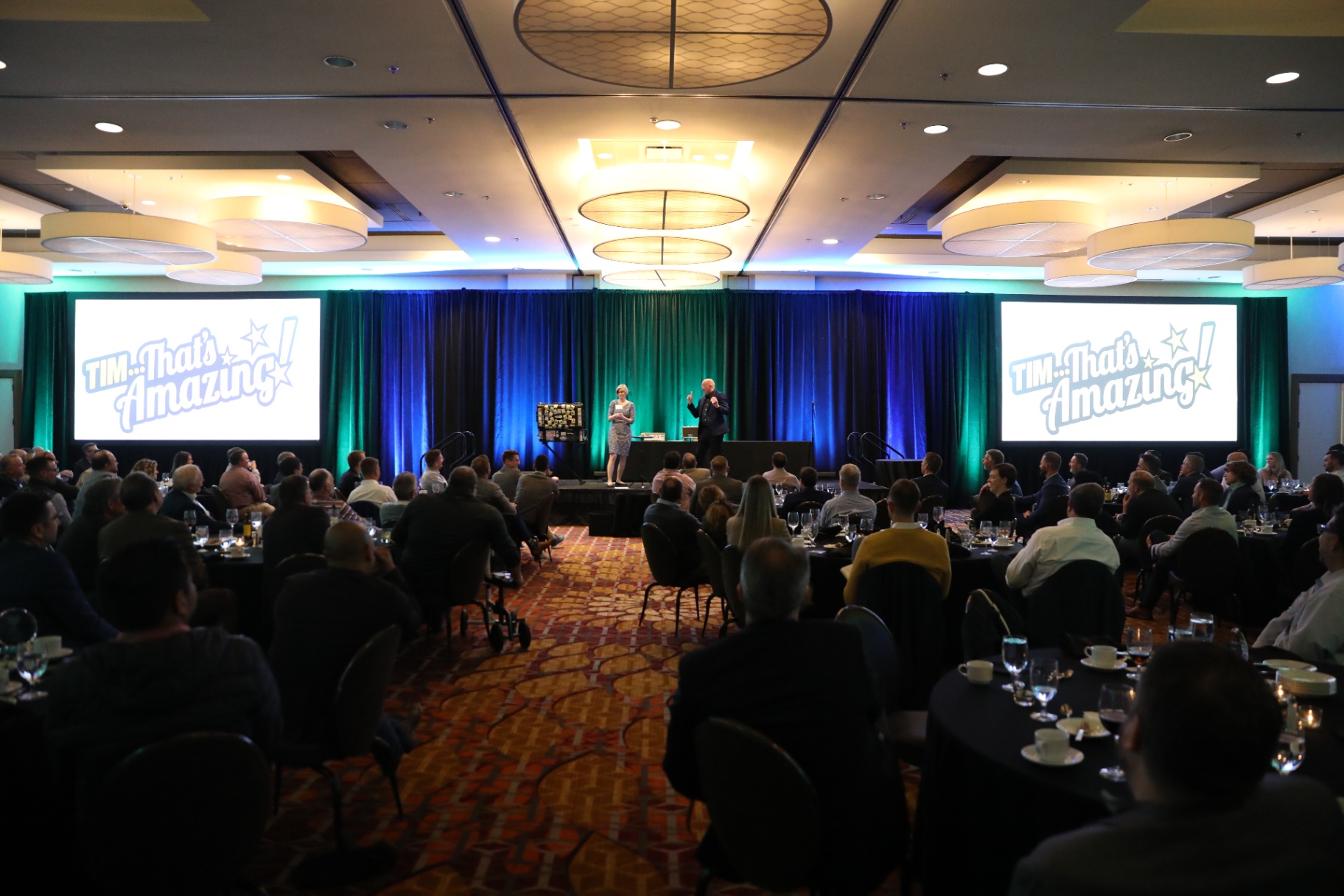 Wide shot of Tim with a corporate audience