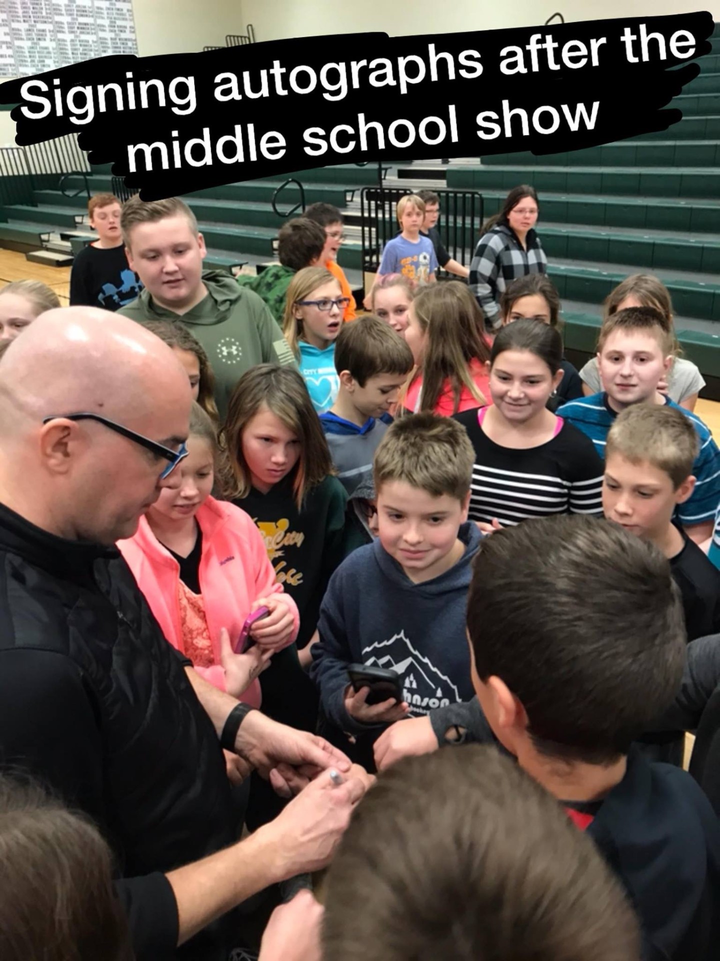 Students crowding around Tim after the show for autographs