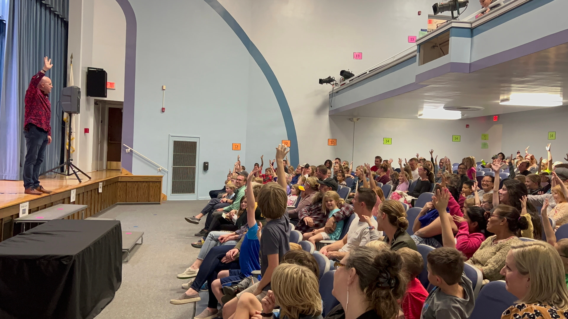 Hands in the air as Tim picks volunteers at Husmann Elementary